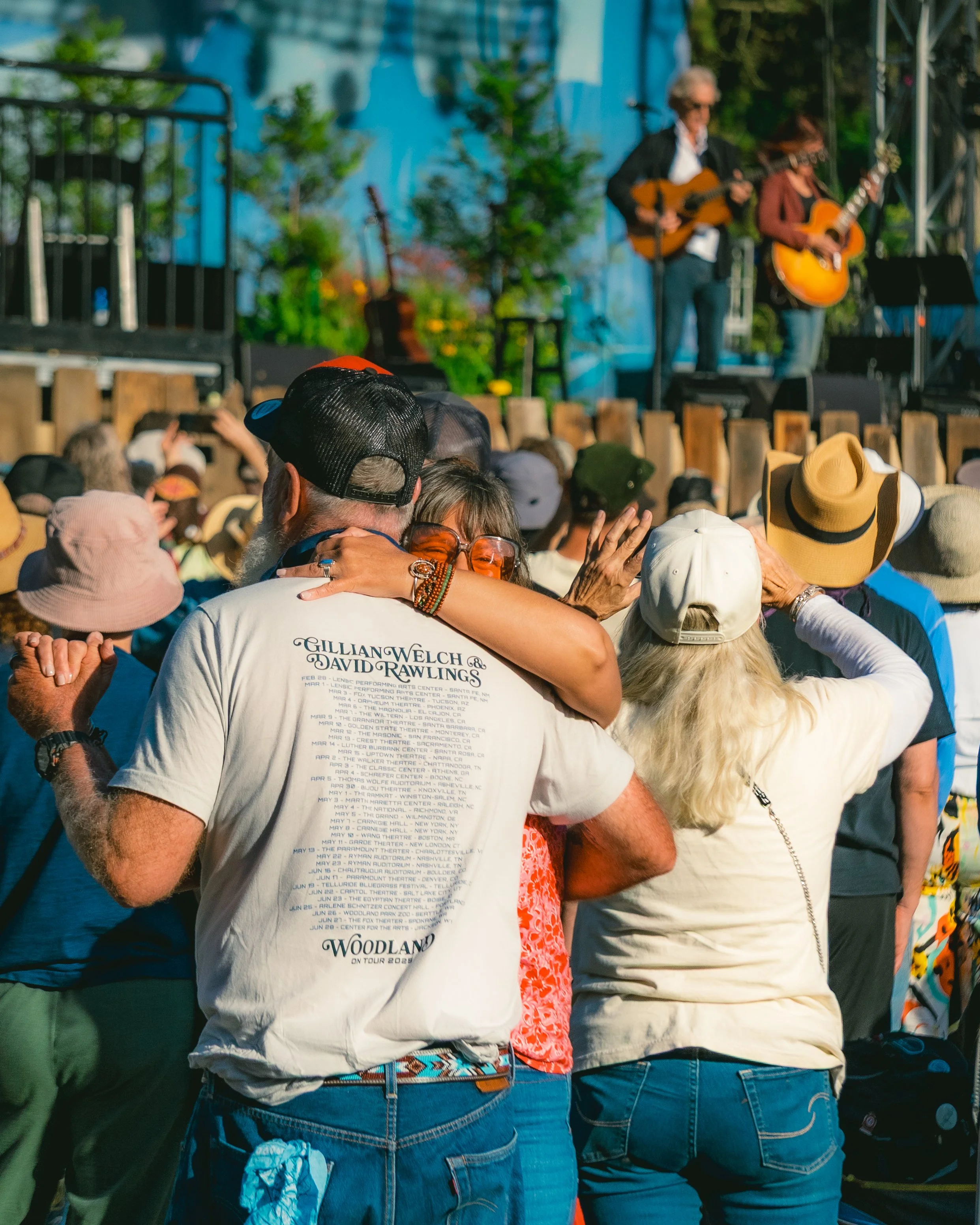 People dancing and enjoying live country music performance outdoors at a festival.