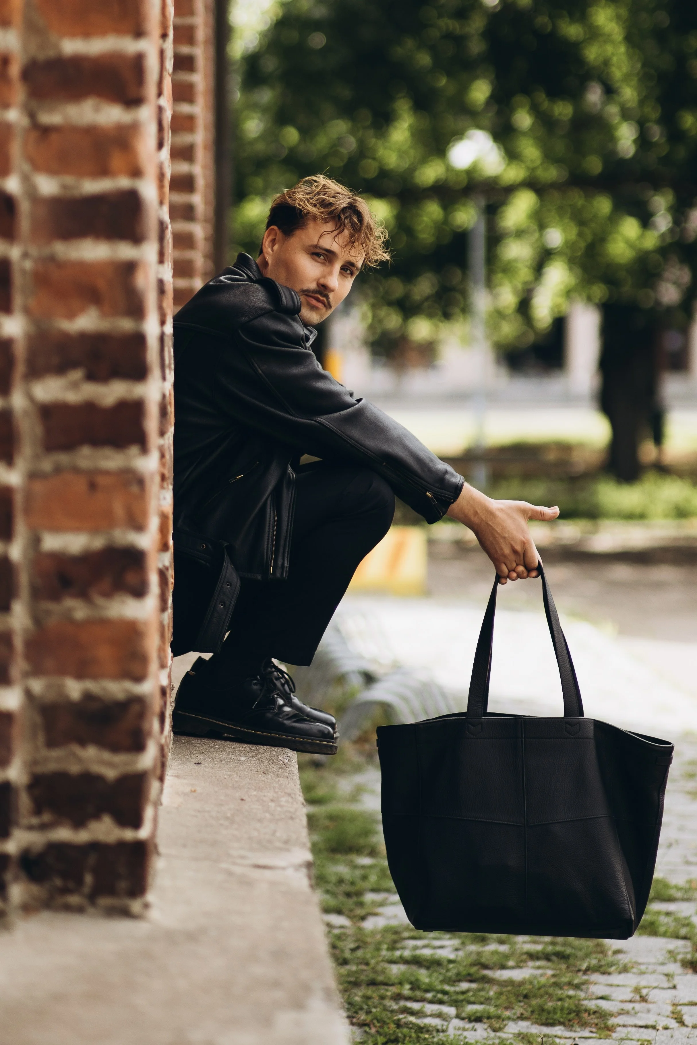 Pesojoonas istuu rappusilla ja katsoo suoraan kameraan. Taustalla puita ja kaupunkimaisemaa.