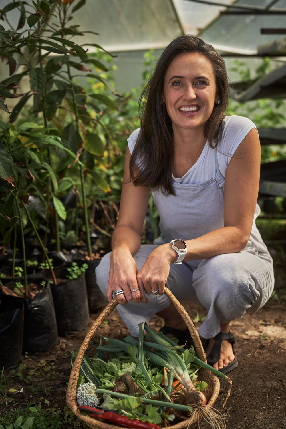 Dietitian Sonia Malczyk in a vegetable garden with a basket of fresh produce