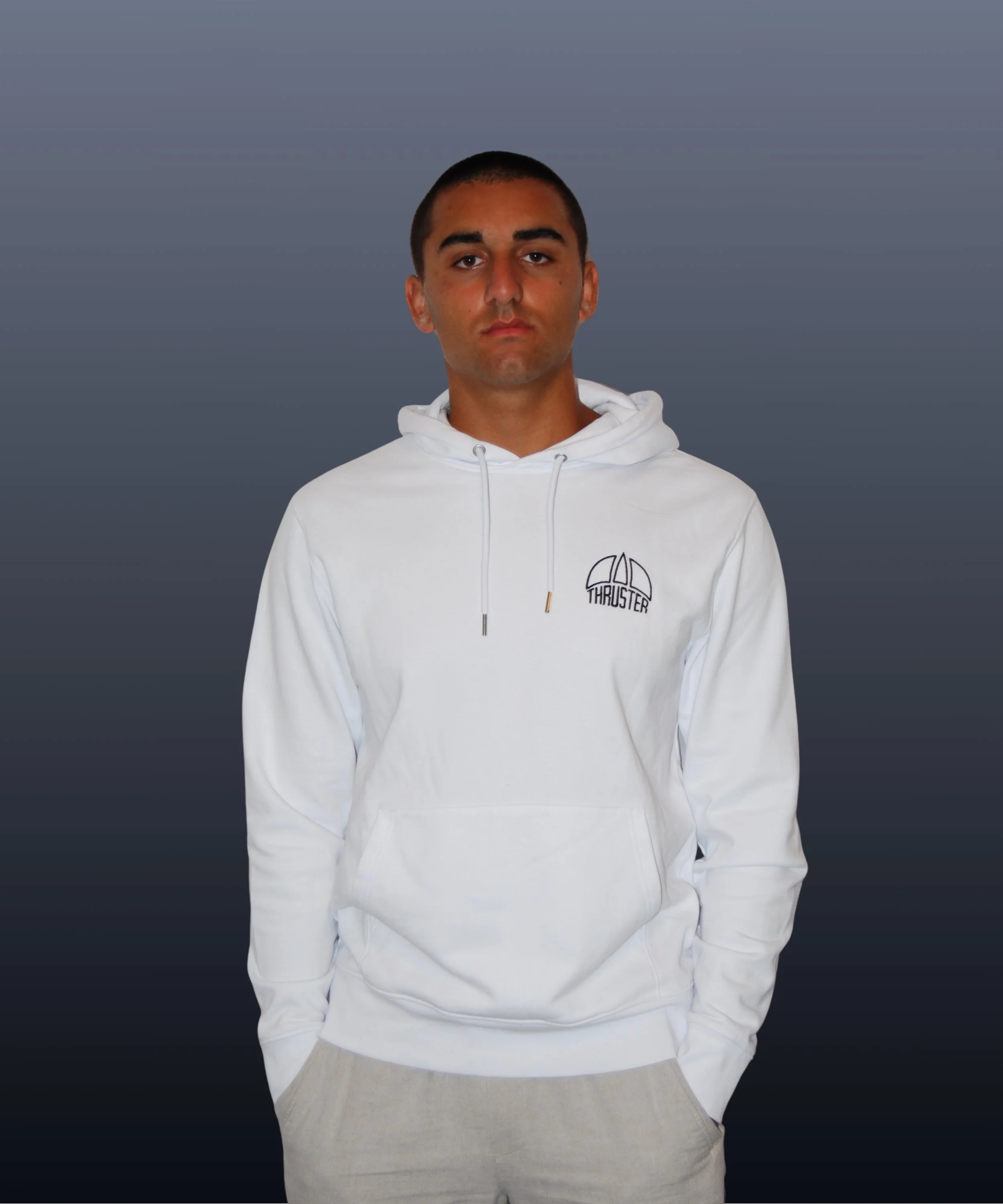 Ragazzo con maglioncino bianco con cappuccio e logo 'Thruster' sul petto, sfondo grigio sfumato