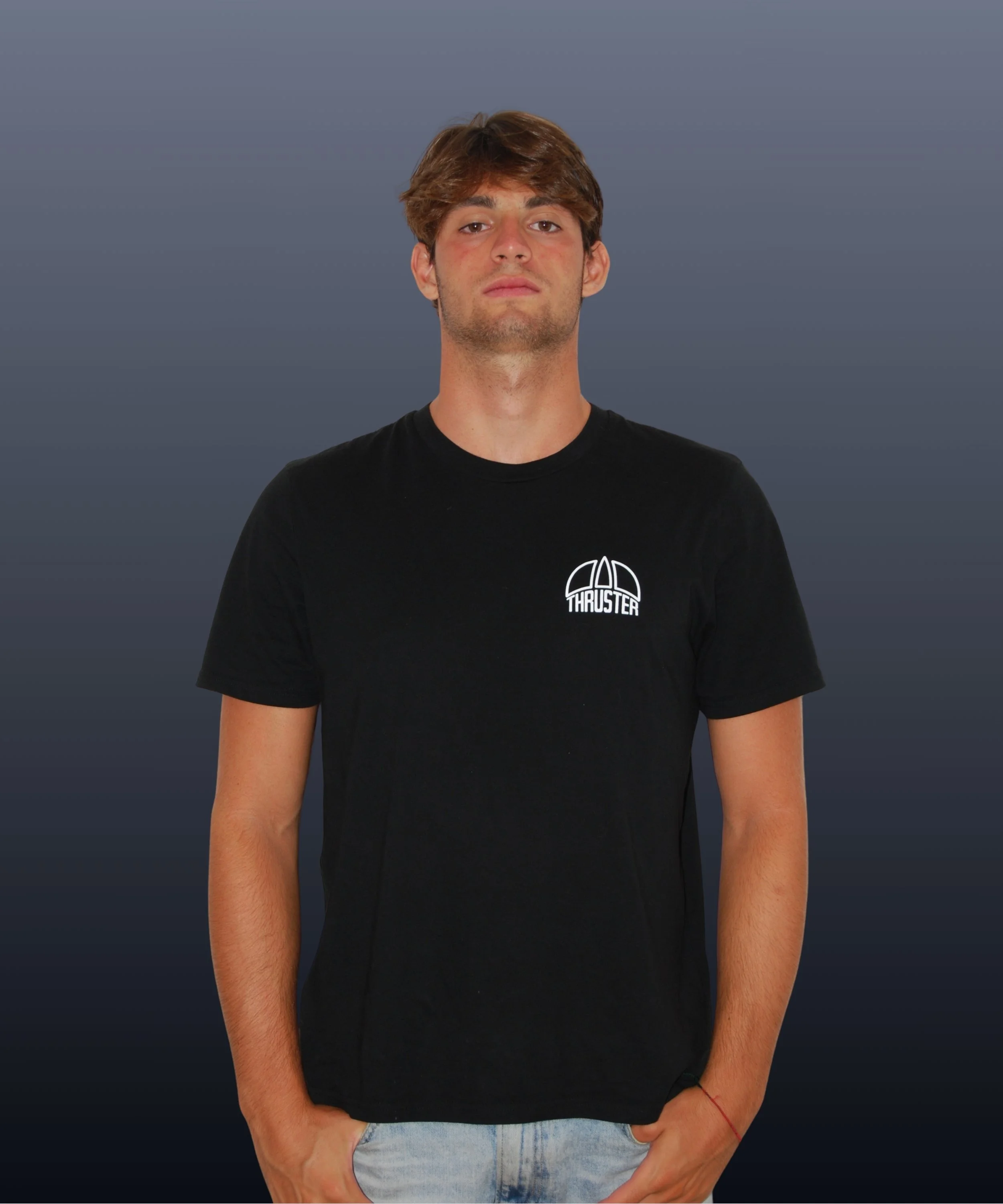 Giovane uomo con capelli castani, vestito con maglietta nera con logo 'Thruster, su sfondo grigio