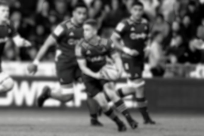 Three rugby players in action during a match