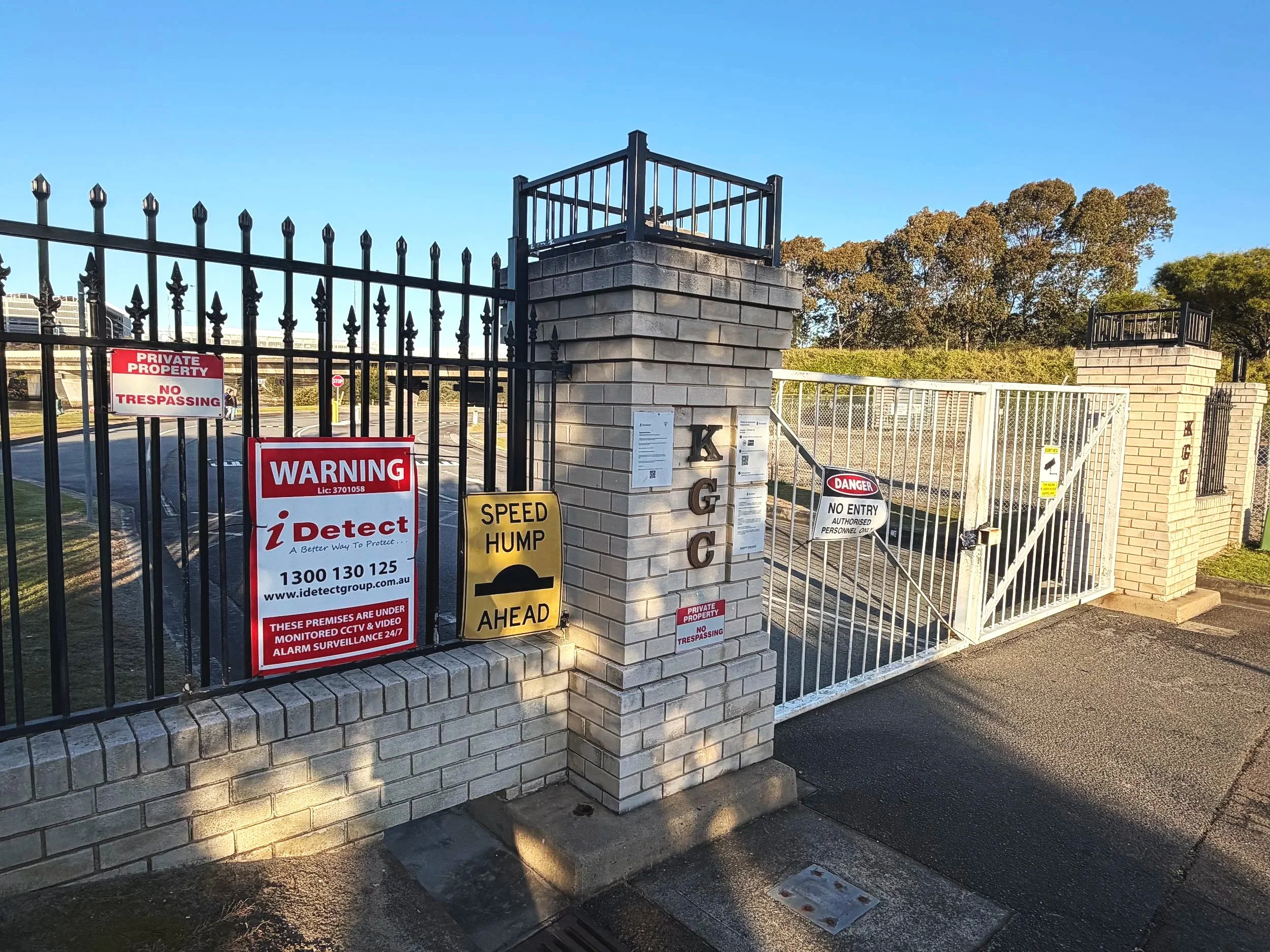 'No Entry' and other warning signs adorn the gates of the Kogarah Golf Club, with brick pylons and a larger black metal fence behind