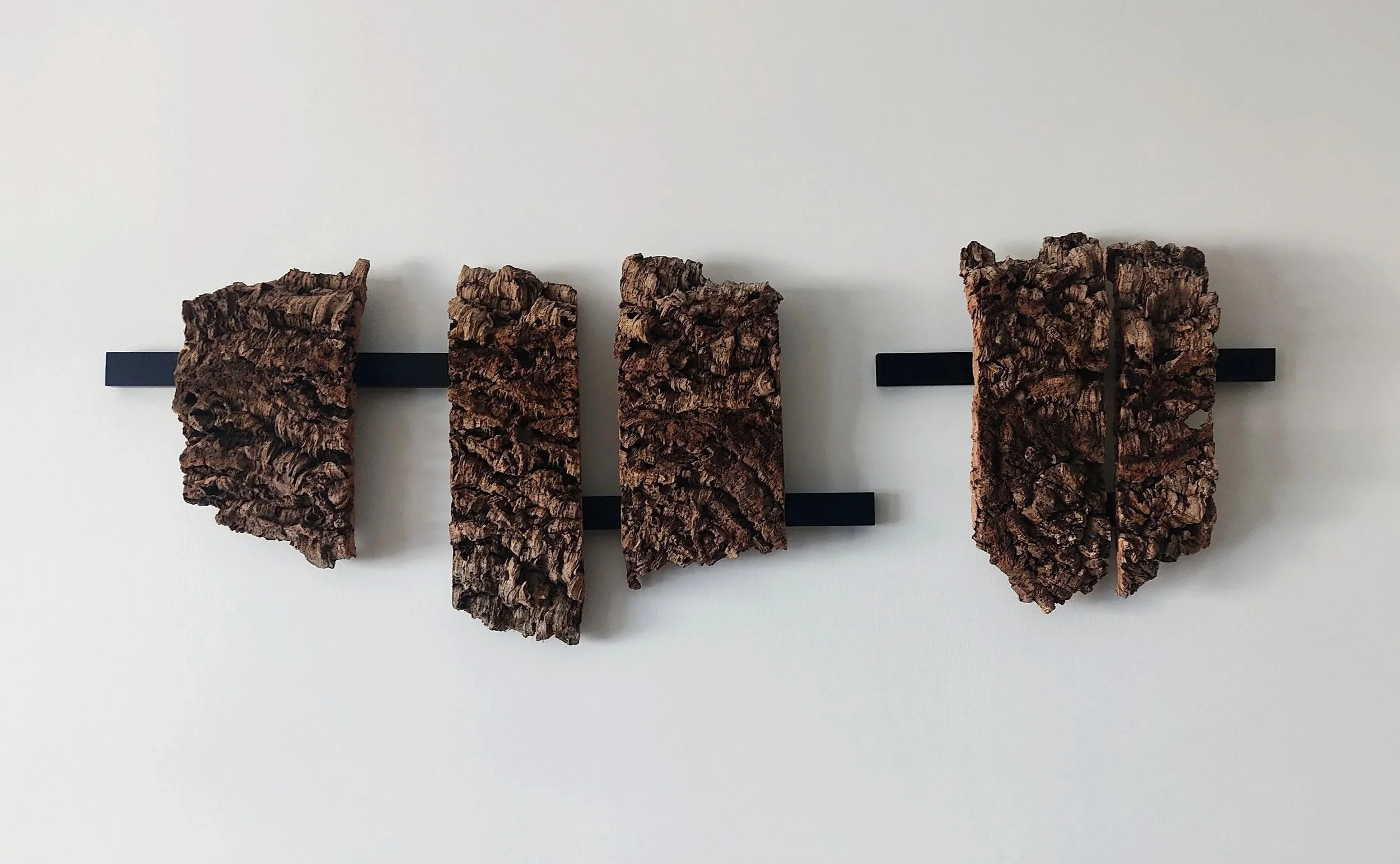 Verdade natural, 2026. Cortiça e metal, 46 x 142 x 9 cm