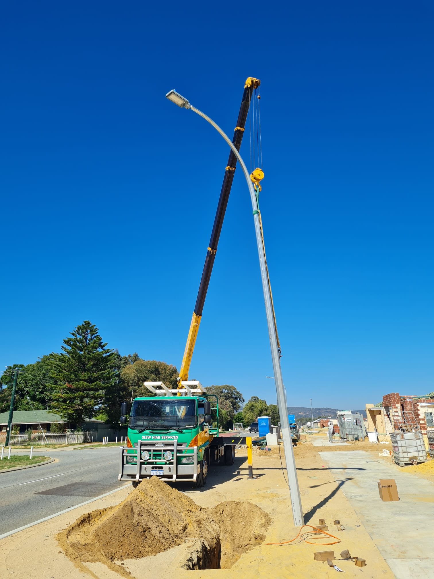 Picture is of a Greens Hiab truck erecting a light pole in a new Perth residential land release development