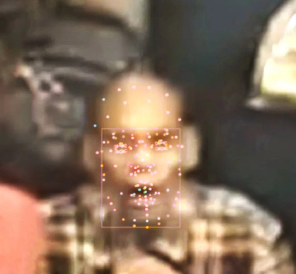 A blurry image of a person with a face scan overlay, showing facial points and features, in an indoor setting. Digital Art. Generative Art. Face detection