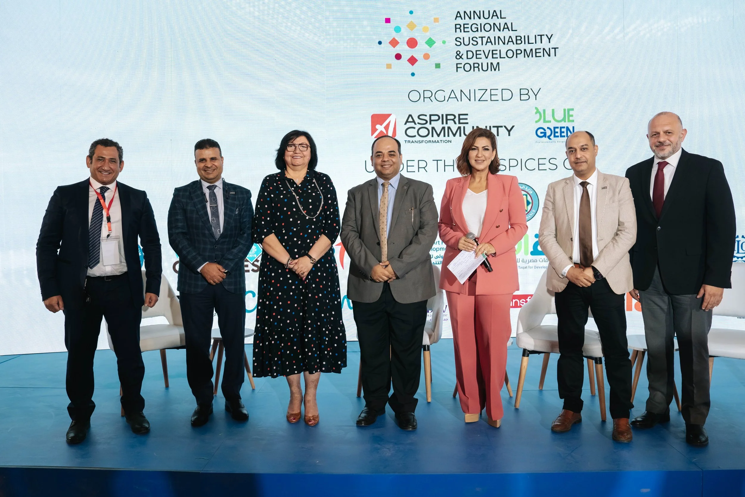 Group of eight RSD Team members standing on stage at the Regional Sustainable Development Forum, First Edition, with a large presentation screen behind them displaying event logos and sponsorships.