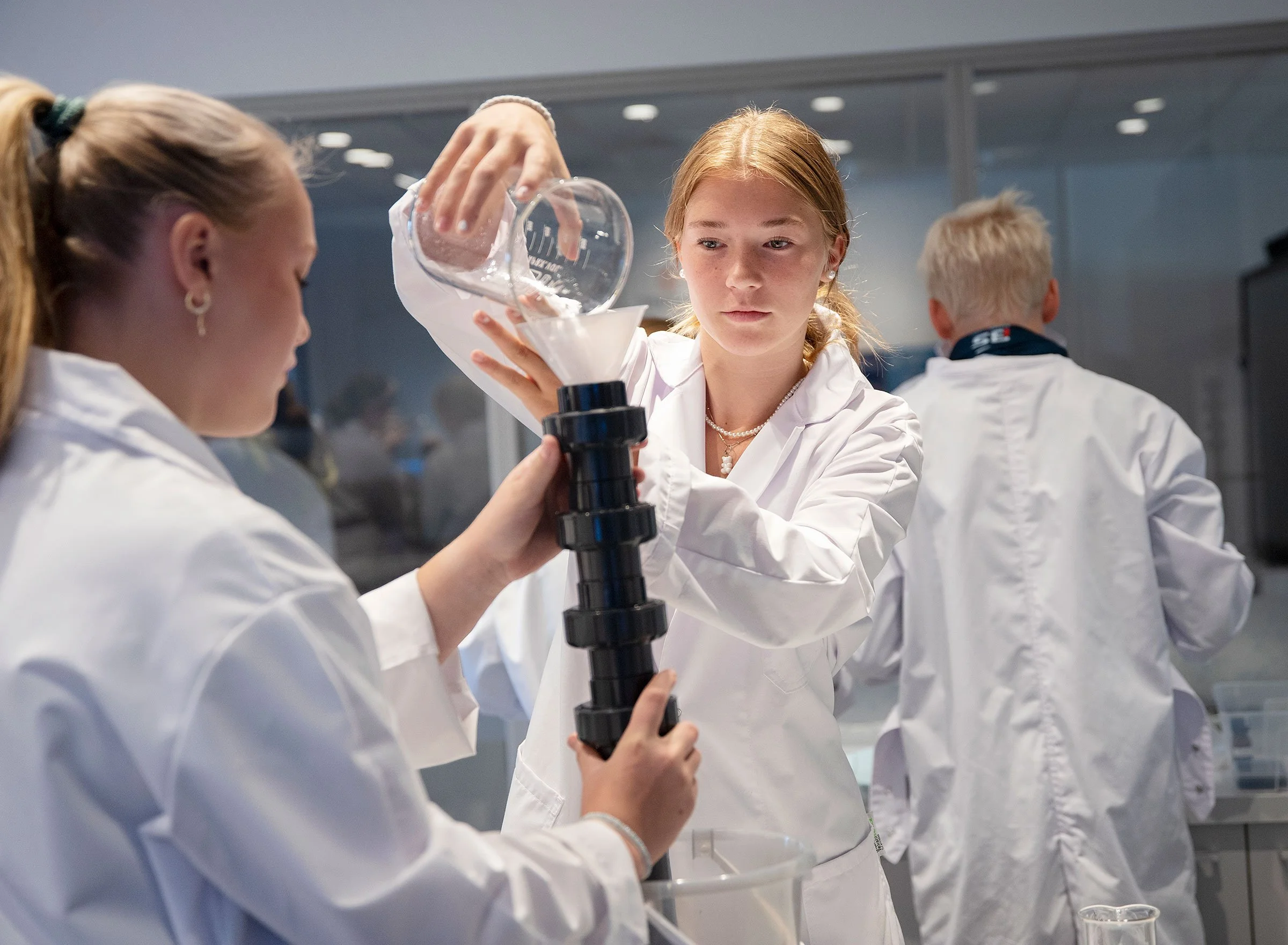 Newton-elever i forsknings frakker heller veske gjennom en trakt.