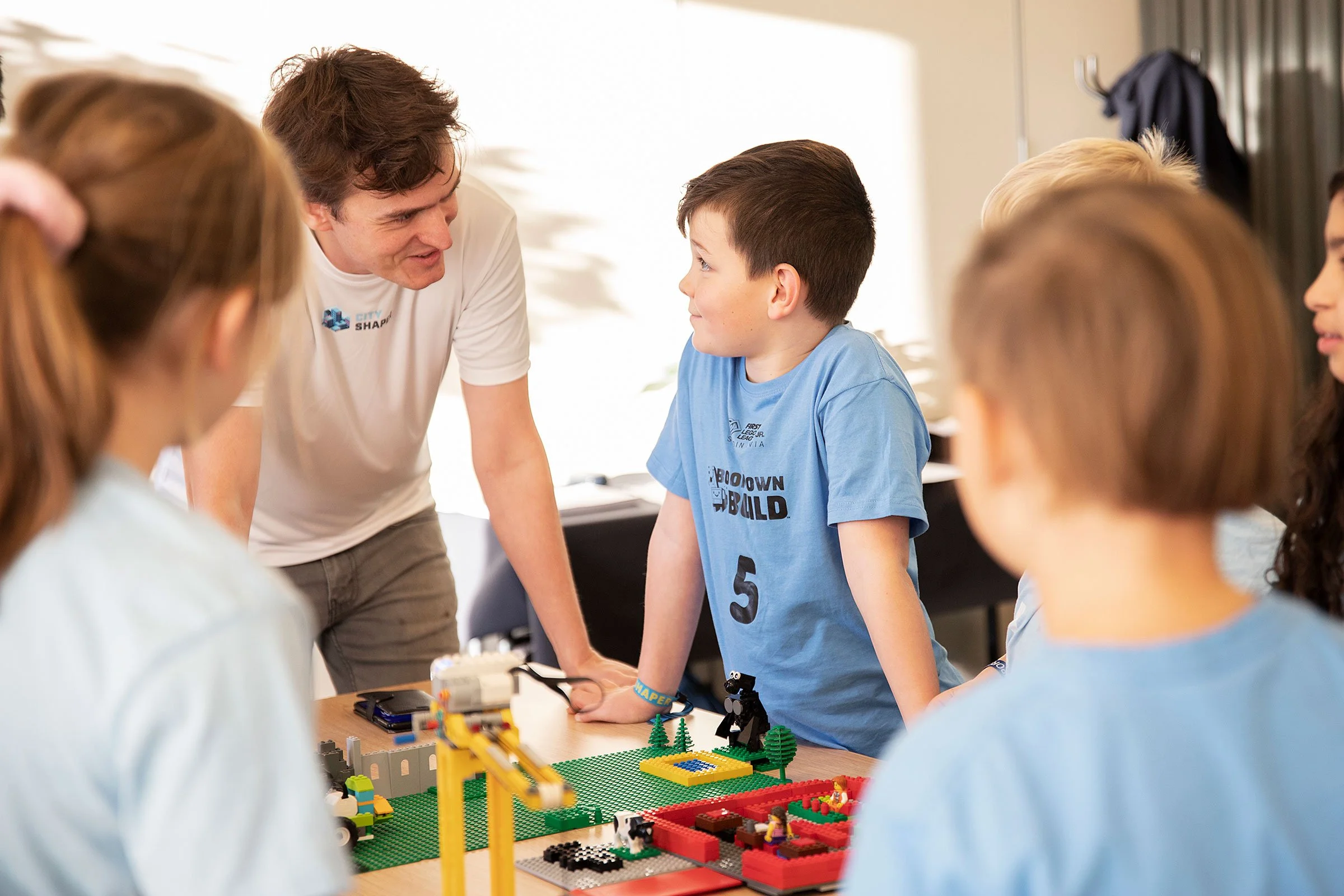 FIRST LEGO League veileder diskuterer med elever.