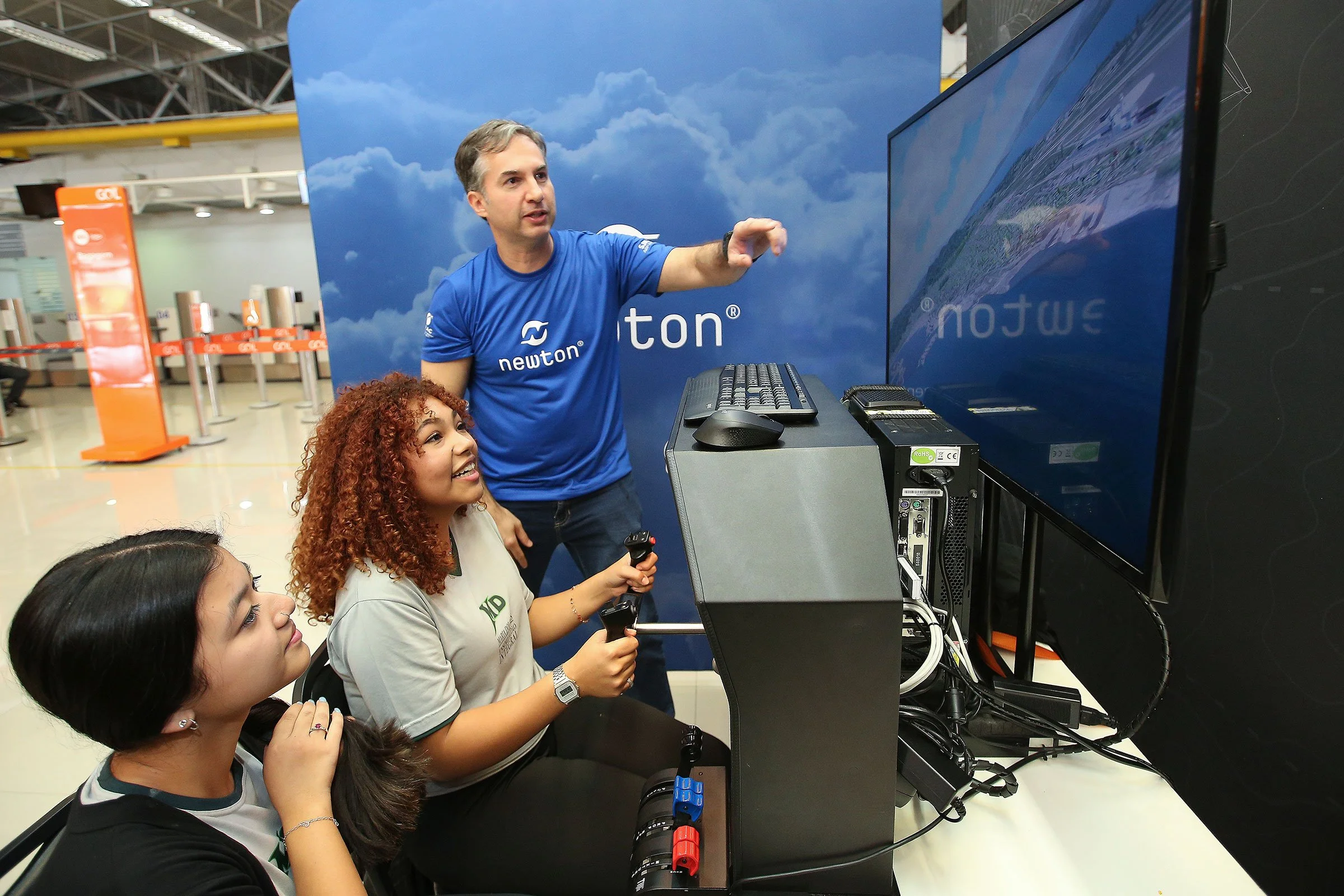 Newton fly instruktør underviser elever som øver med flysimulator.