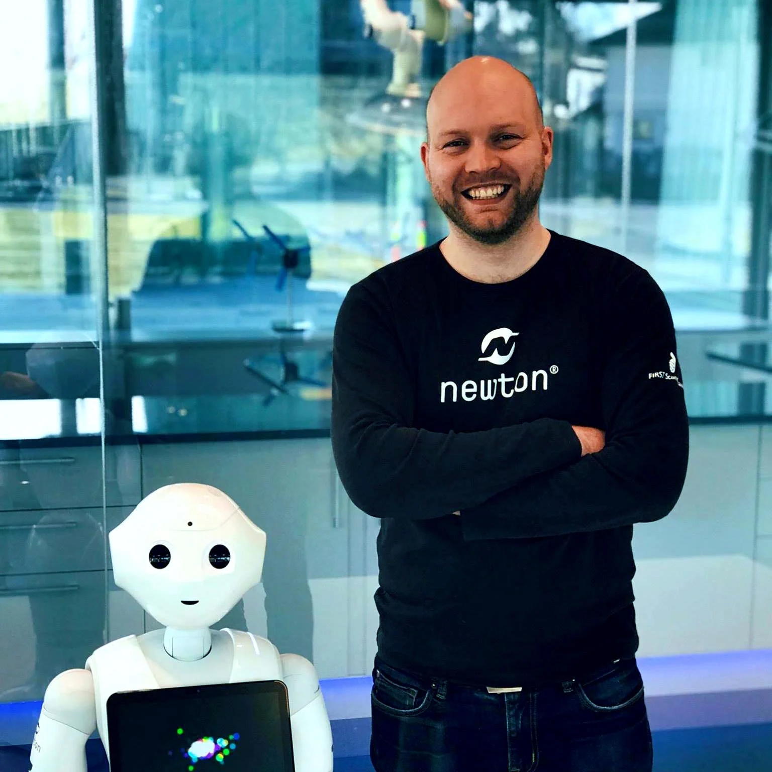 Newton-lærer sammen med Pepper robot i Newton-rom.