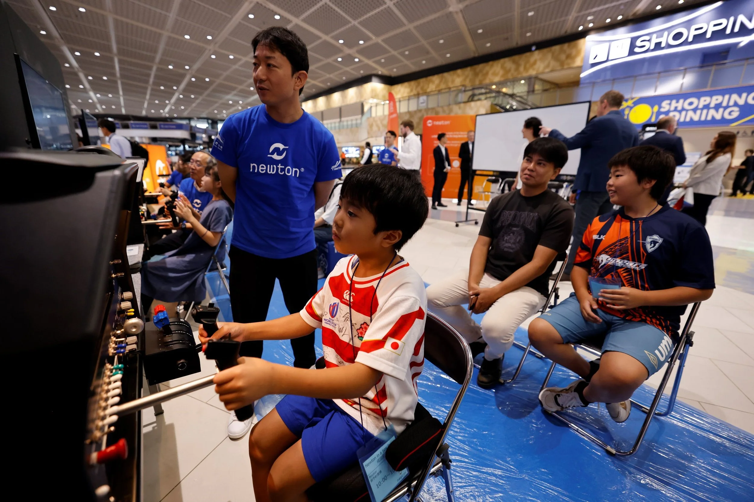 Barn prøver ut flysimulator på Newton in a Box, Japan.