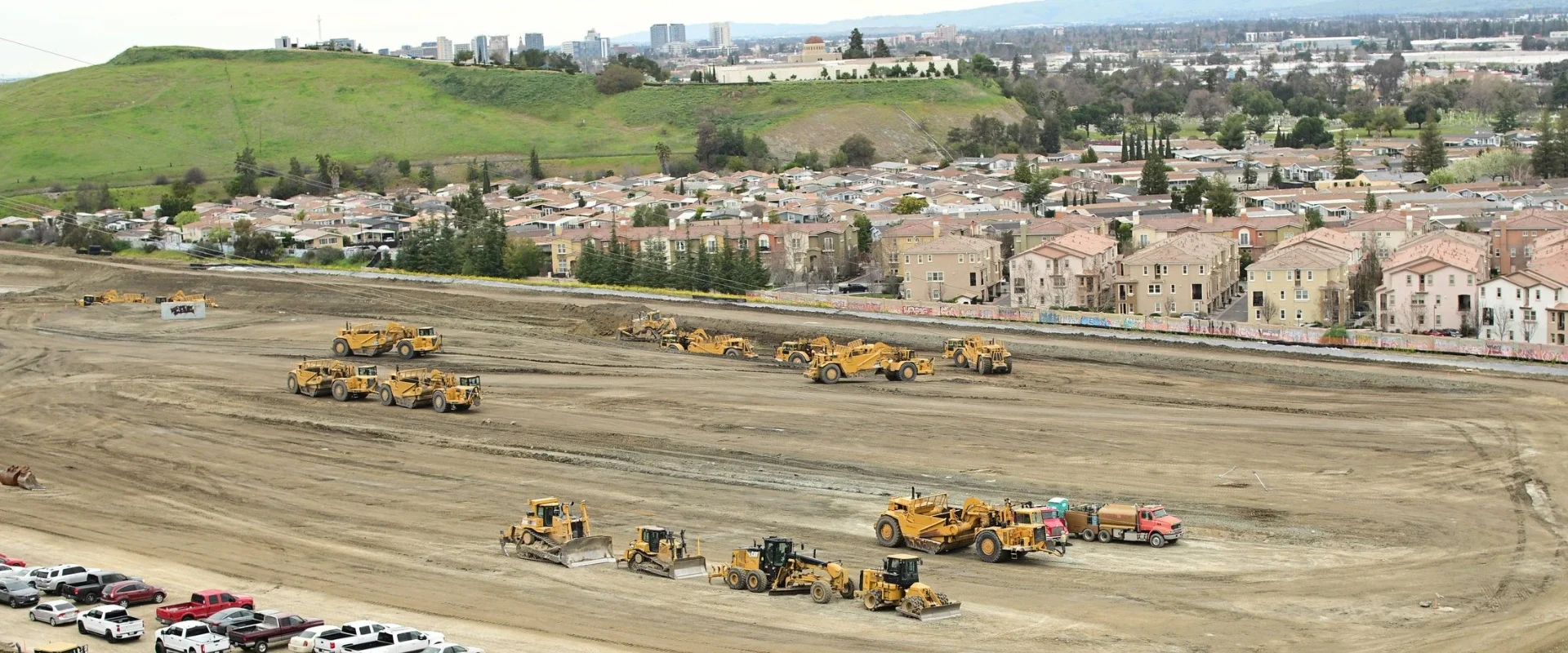 Aerial view of grading operations at Communications Hill in San Jose, California, where heavy construction equipment is excavating and leveling one of the city's highest points to prepare residential building sites for home development.