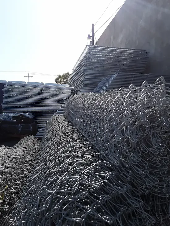 Piles of metal chainlink fencing stacked outdoors.