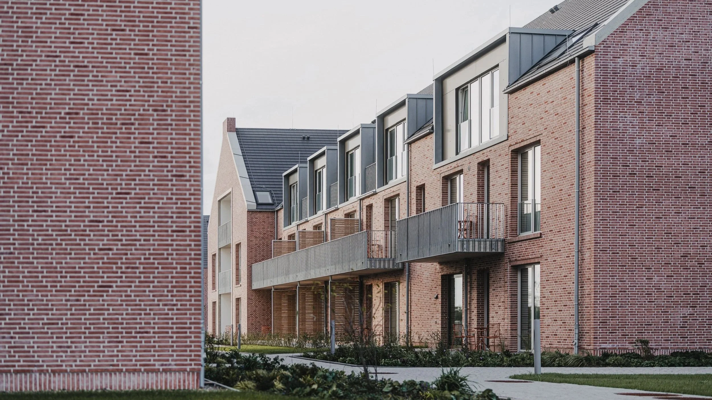 Moderne mehrstöckige Wohngebäude mit grüner Gartenfläche und Balkon in modernen Wohnkomplex.