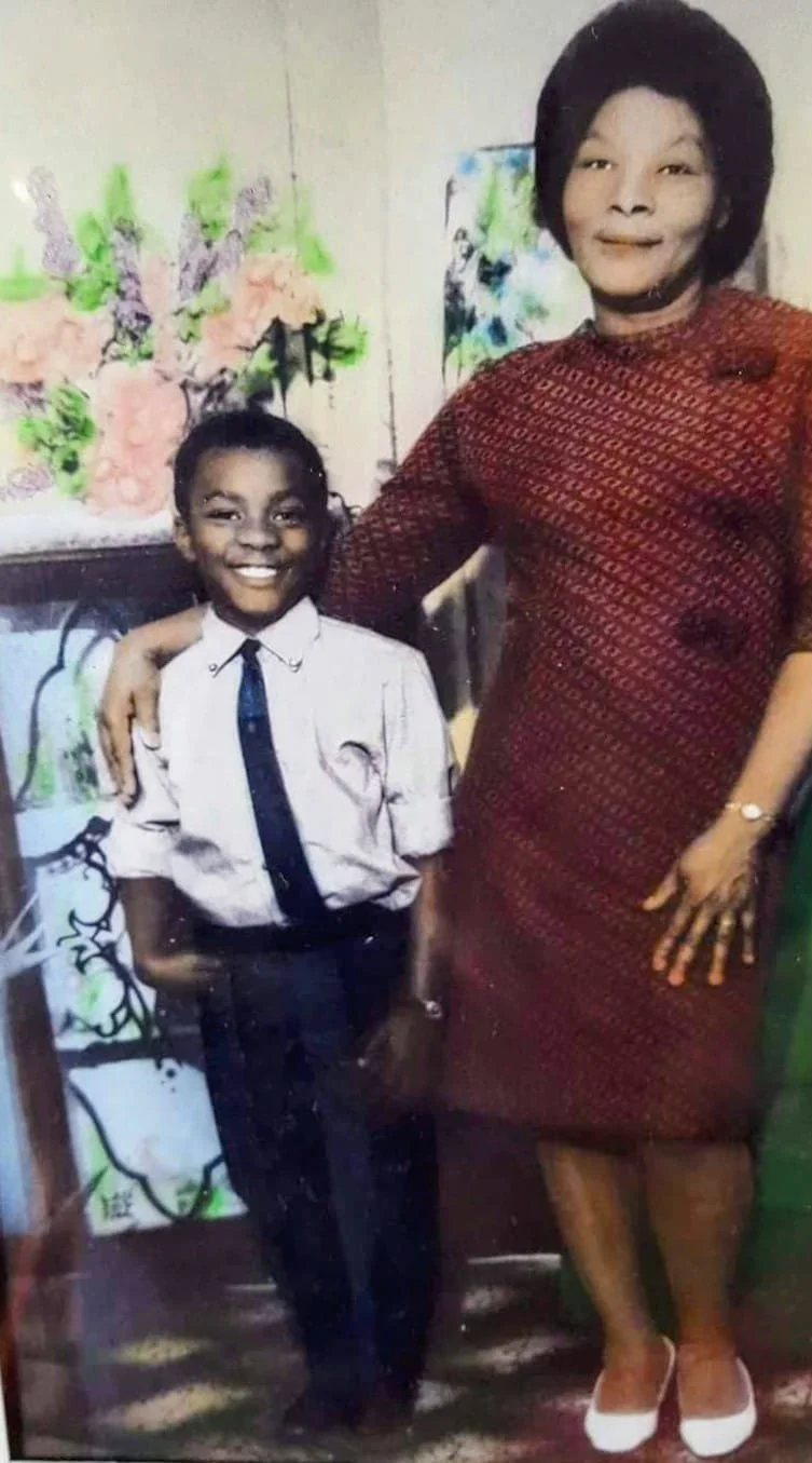 Vintage family photograph of Olive Drummond, a Walsall Windrush Sister, standing with her young son in a patterned red dress, capturing Caribbean heritage and family life in the West Midlands.