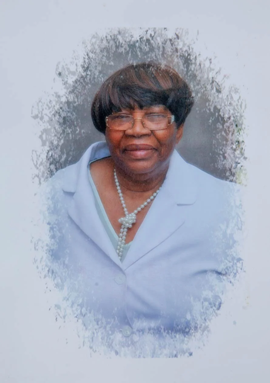 Lizzie Jackson photographed in her later years, wearing pearls and a pale blue jacket — part of the Walsall Windrush Sisters oral stories honouring Caribbean women's lives in the West Midlands.