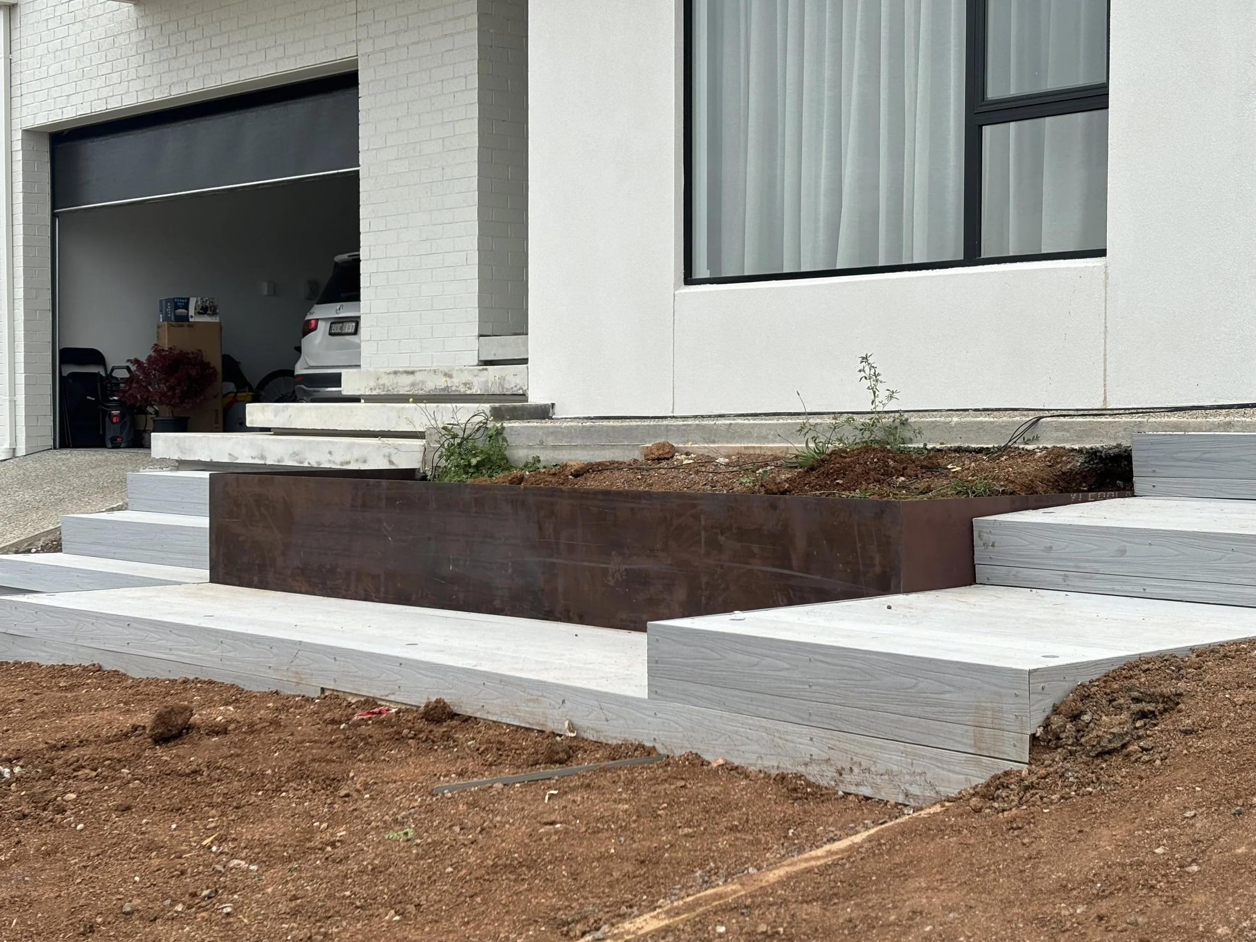 Steel and corten planter box in front of a modern house 