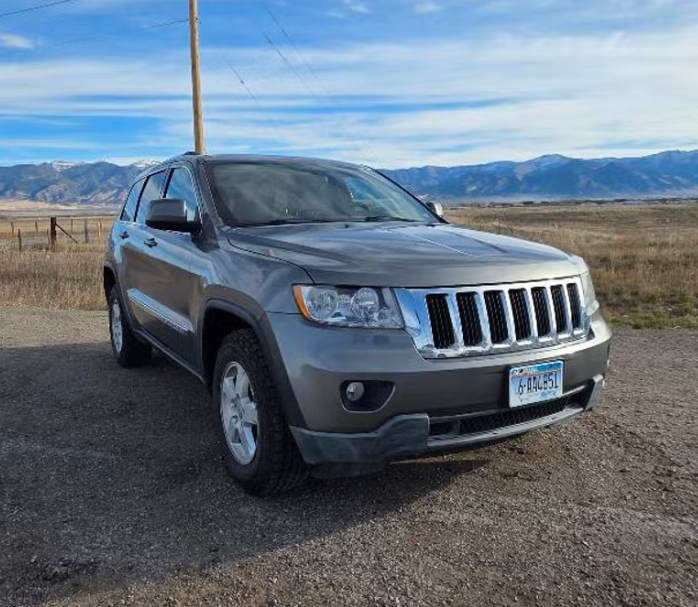 Brown suv parked on a mountain road 