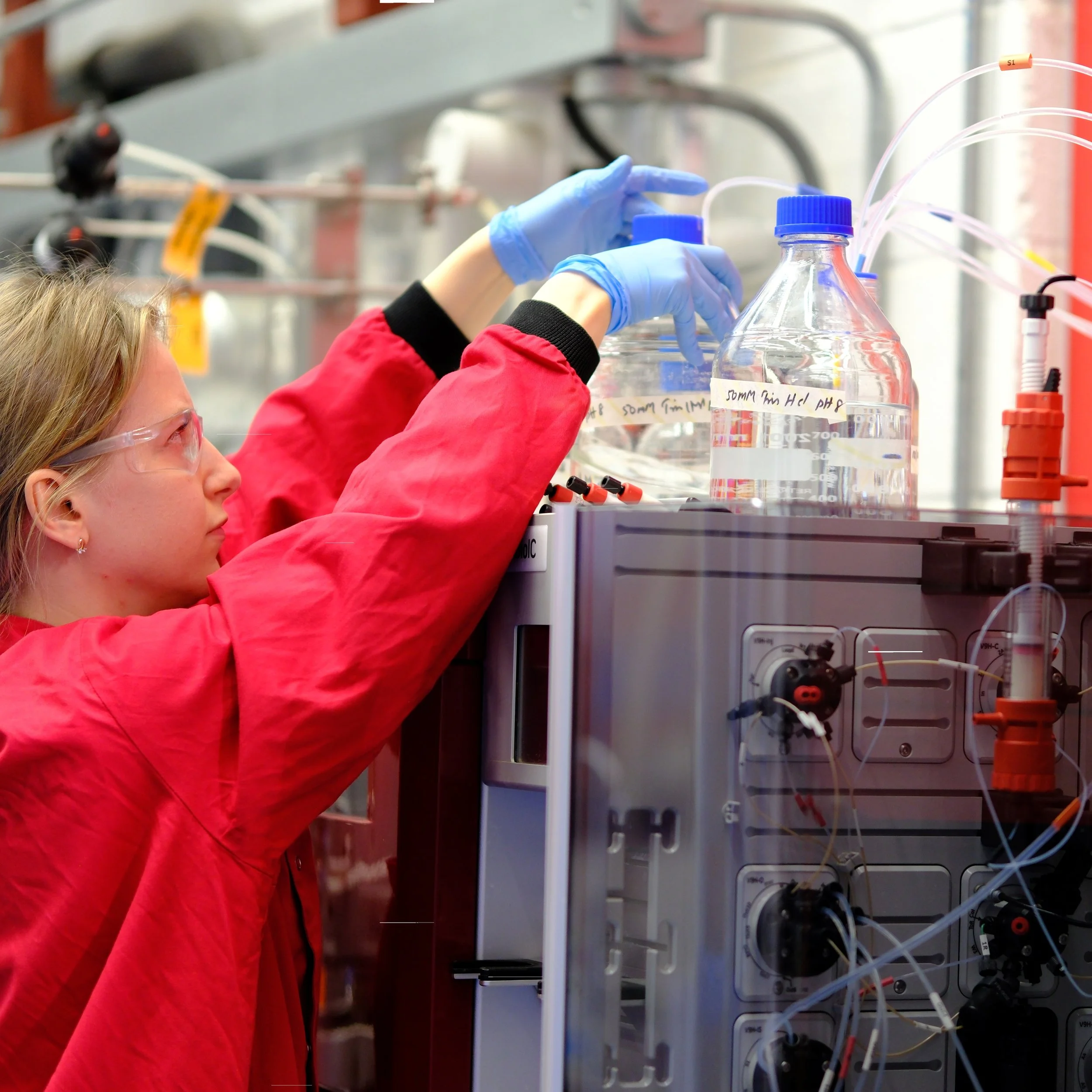 Scientist operating an FPLC system for protein purification in a laboratory.