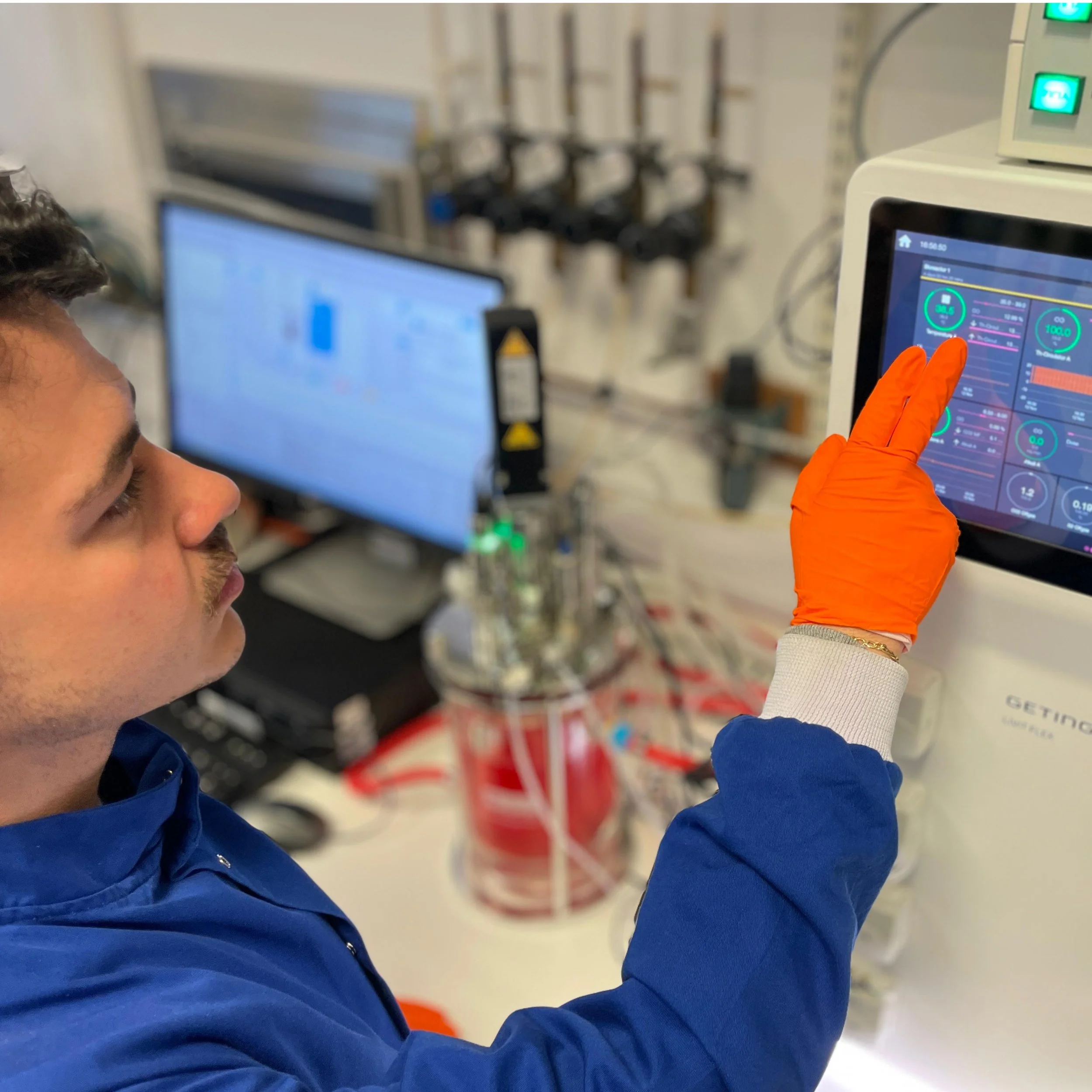 Scientist operating a bioreactor controller for monitoring and control of cell culture and bioprocessing parameters.
