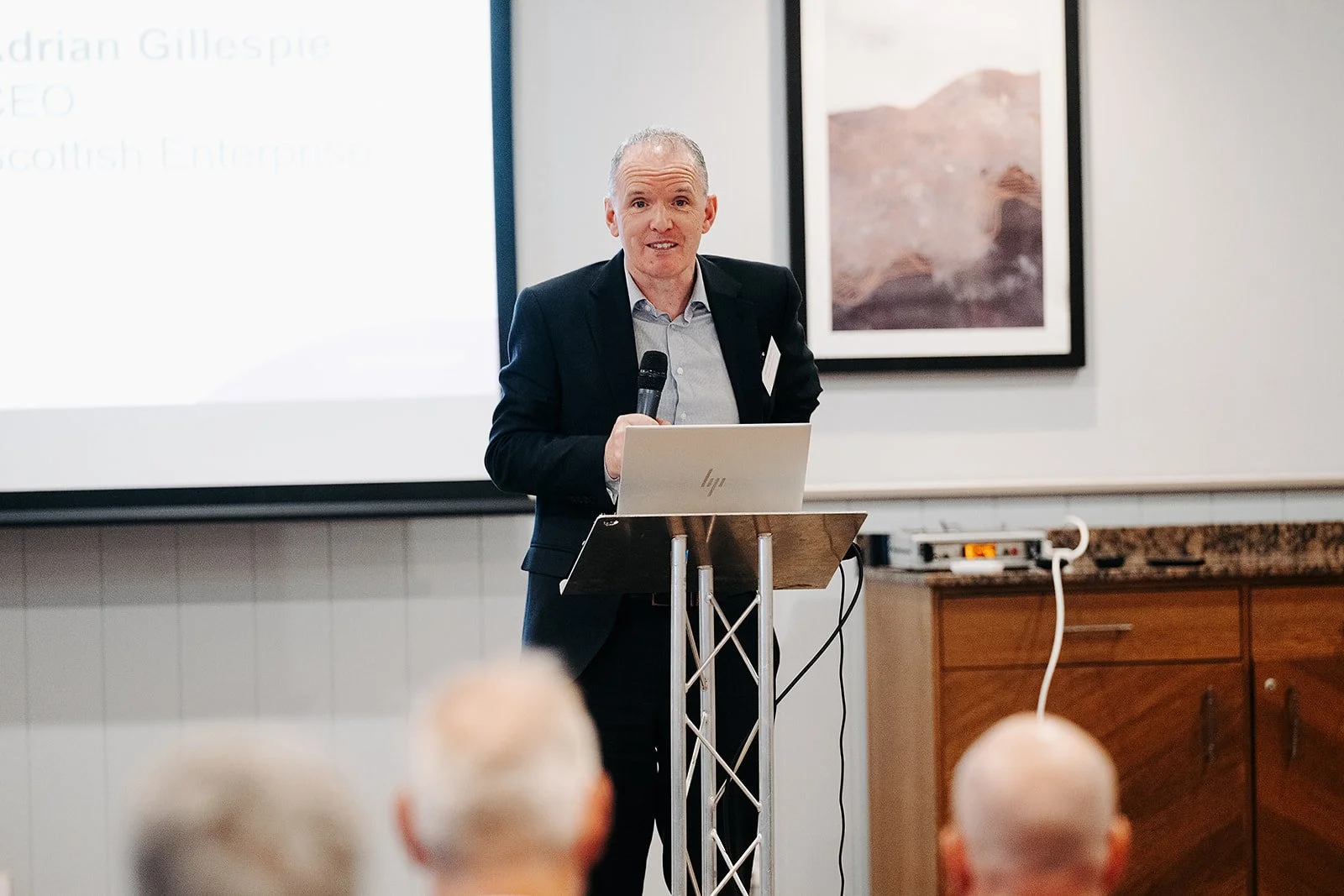 Adrian Gillespie, CEO of Scottish Enterprise,, delivering a speech at a podium at the CMO Showcase event for the Scottish BioBased Manufacturing Launchpad programme in Glasgow on 7 October
