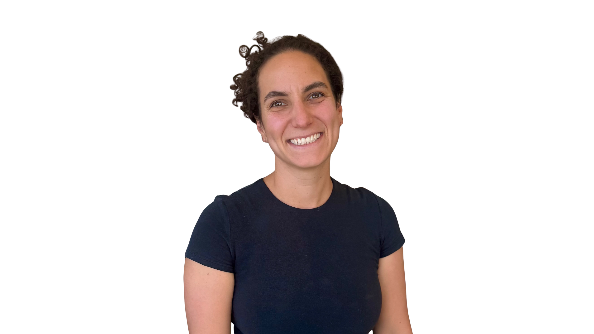 Portrait of a woman with long dark curly hair smiling, wearing a black top against a dark background.