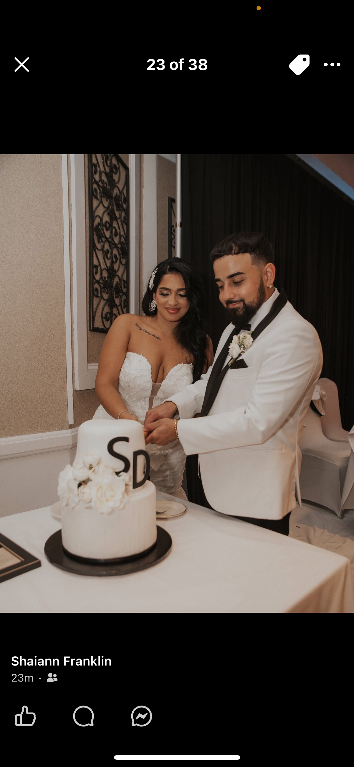 A bride and groom cutting a wedding cake together at their wedding reception.