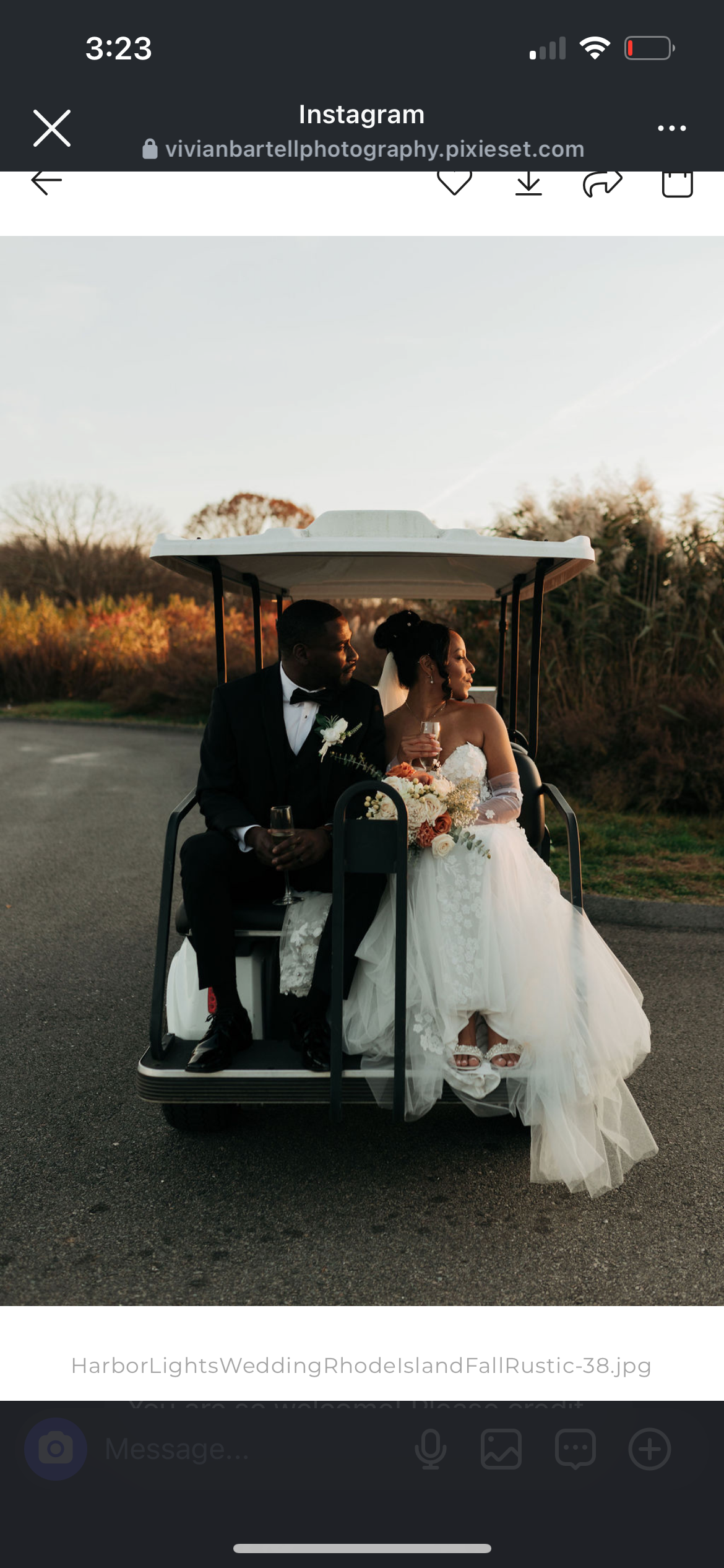 A bride and groom sitting in a golf cart outdoors at sunset, both holding glasses of champagne, with the bride holding a bouquet of flowers.