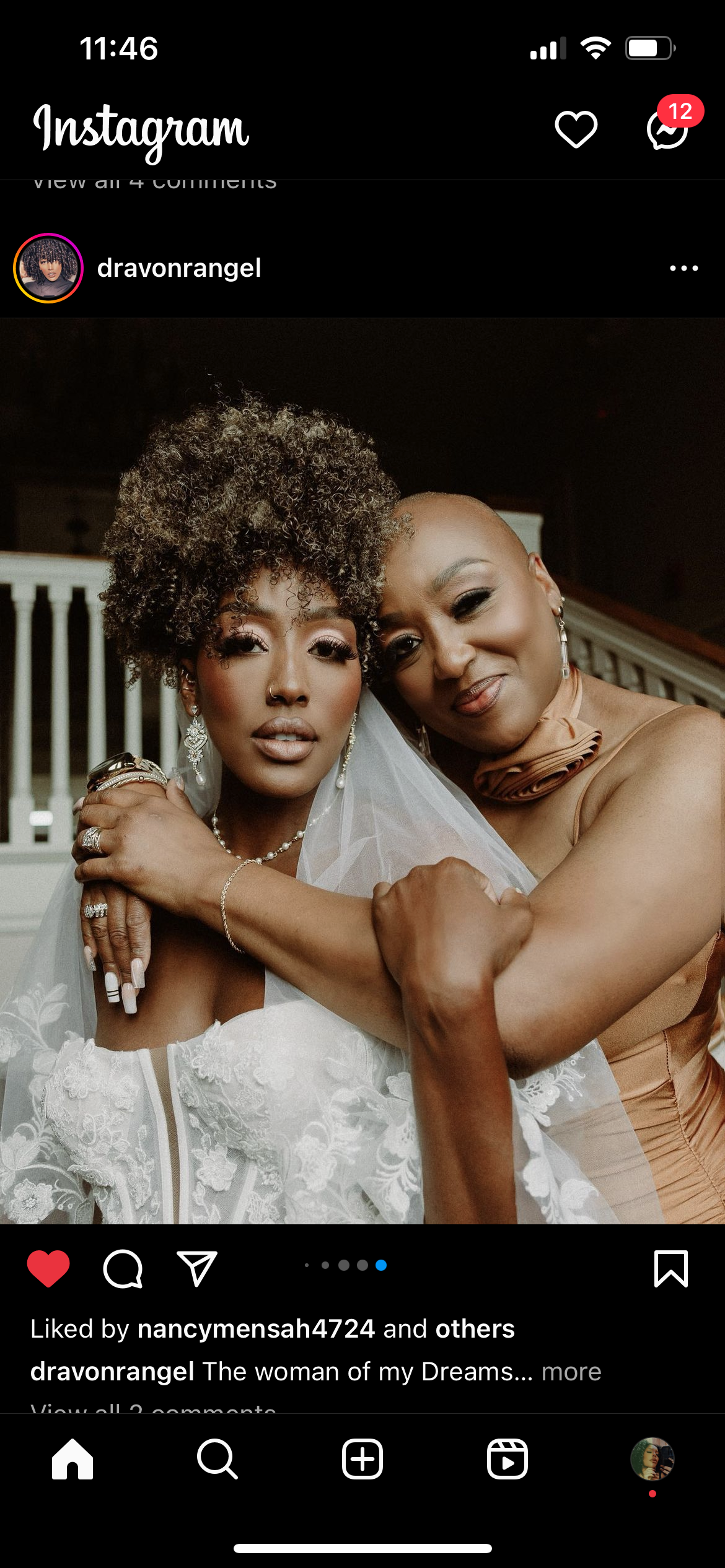 Two women hugging, one with curly hair and the other with a shaved head, in a warm embrace at a wedding or special event.