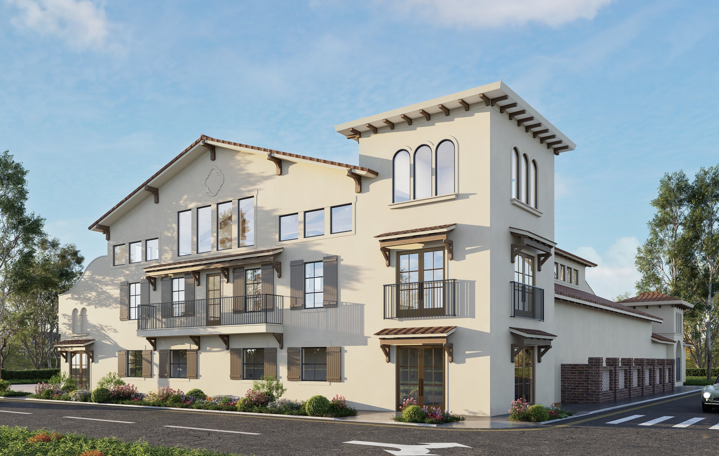 A three-story modern house with white exterior walls, brown window shutters, and small balconies with black railings. The house has a gabled roof with multiple sections, including a tower-like structure with three arched windows. There are trees and landscaped bushes in front, and a car is partially visible on the street nearby.