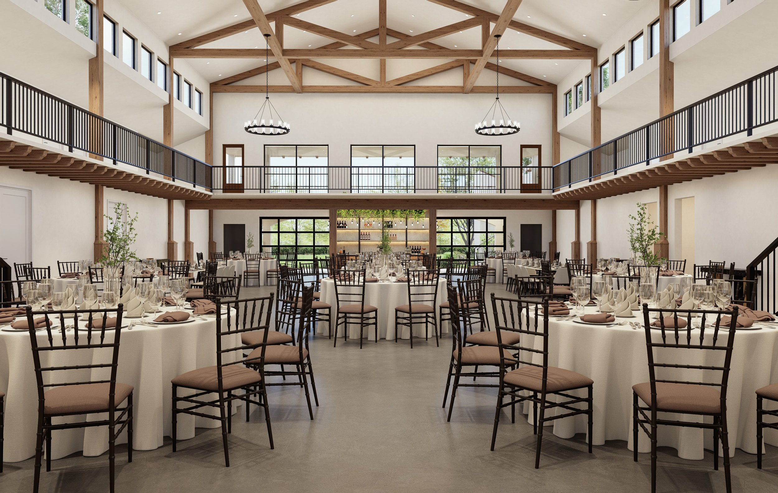 An elegant indoor event space set up for a banquet with round tables covered with white tablecloths, neatly arranged glassware, napkins, and silverware, surrounded by brown chairs with beige cushions, and a two-level wooden hall with high ceilings, large windows, and chandeliers hanging from wooden beams.