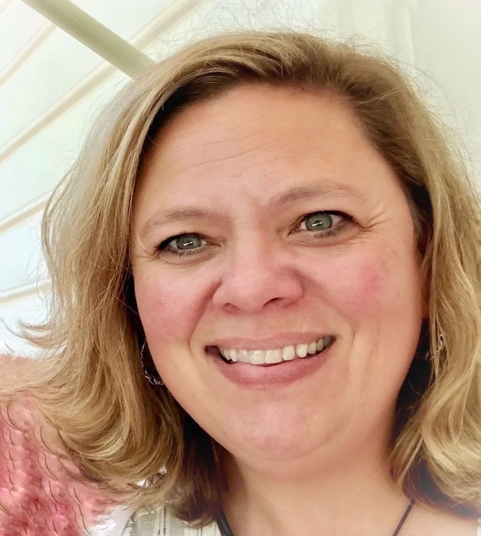Olivia is a white woman, wearing a pink shirt, smiling & looking at the camera."