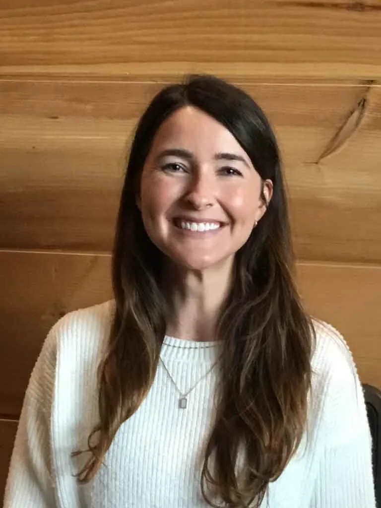 Smiling, white female standing against wood paneling