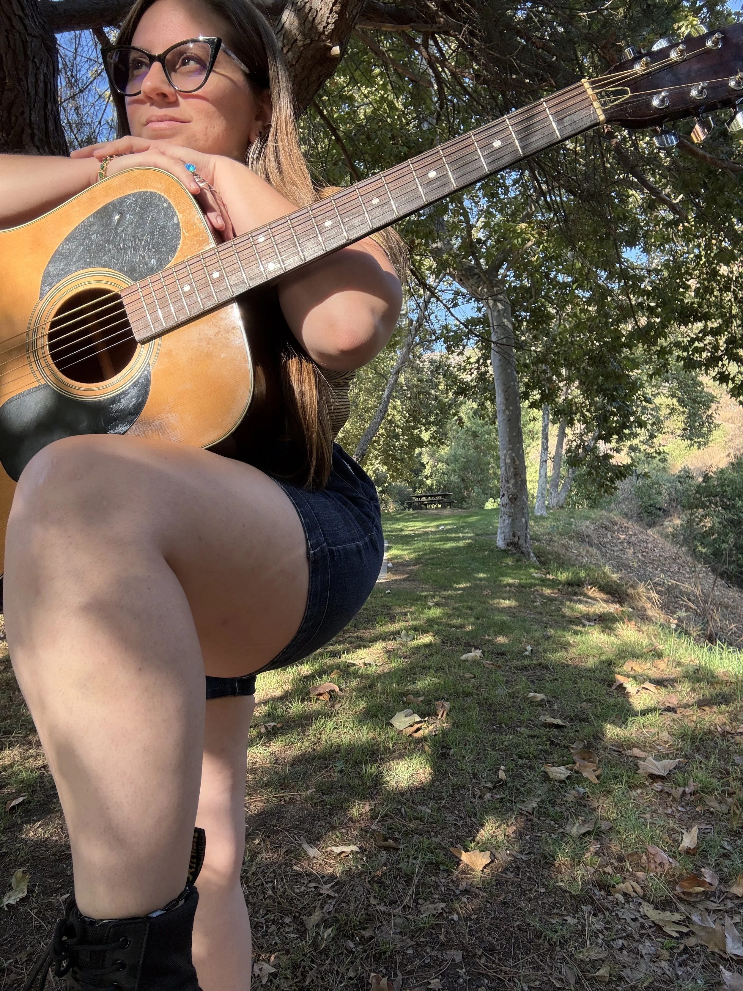 woman holding a guitar looking into the distance
