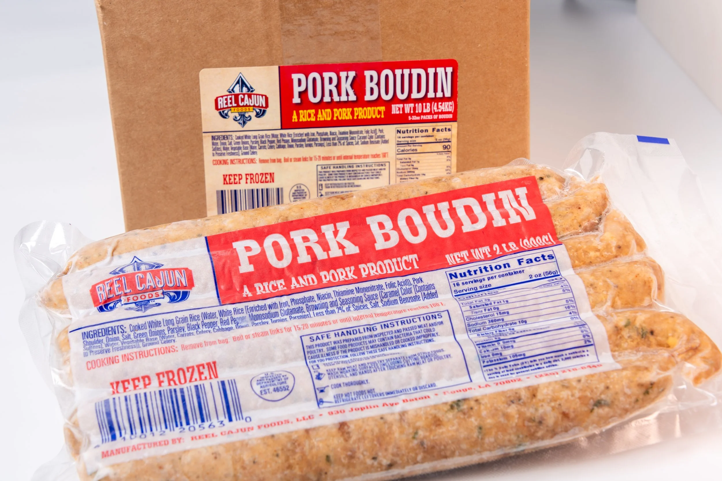 Packaged pork boudin sausage in clear plastic with a cardboard box in the background.