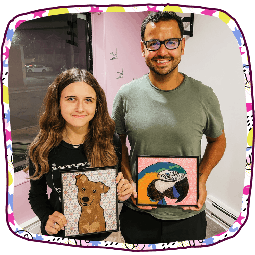 father and daughter holding up art projects they made together