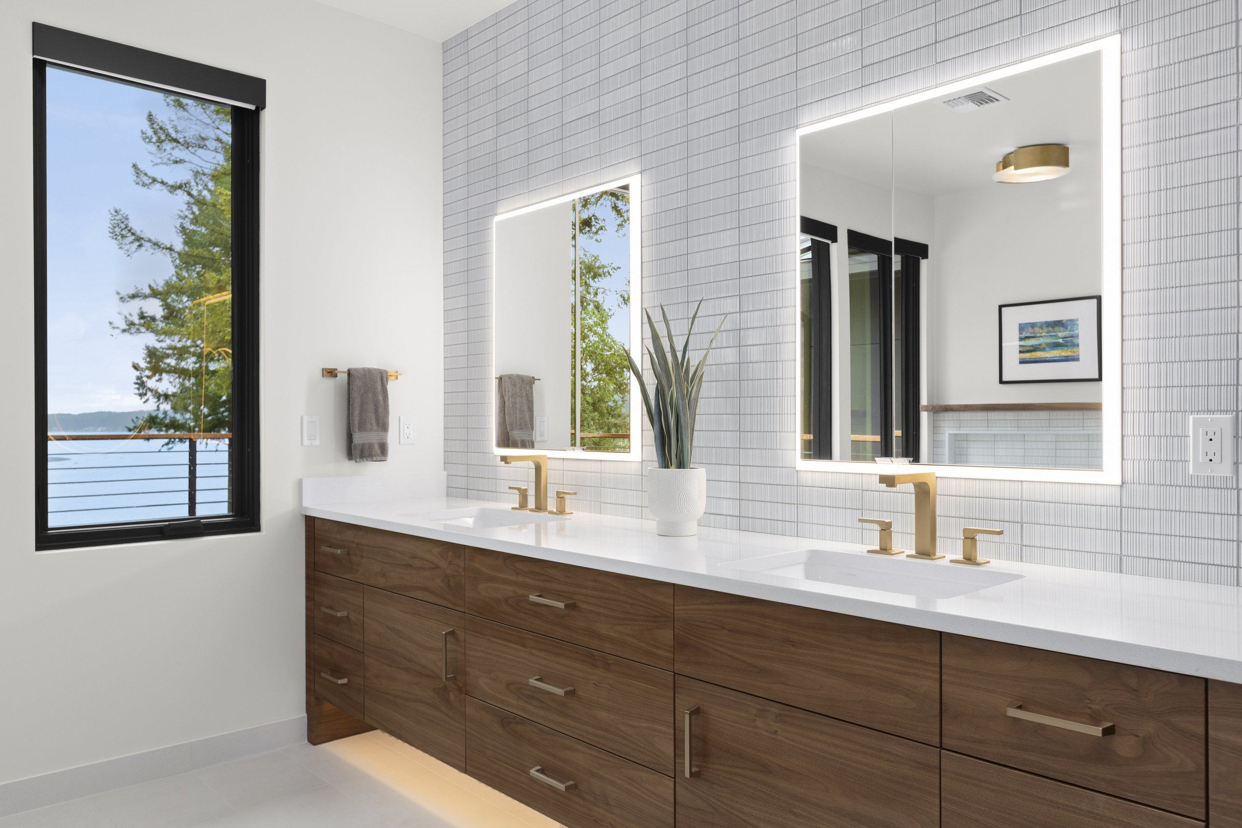 Secondary bathroom vanity detail with walnut cabinetry and tile backsplash
