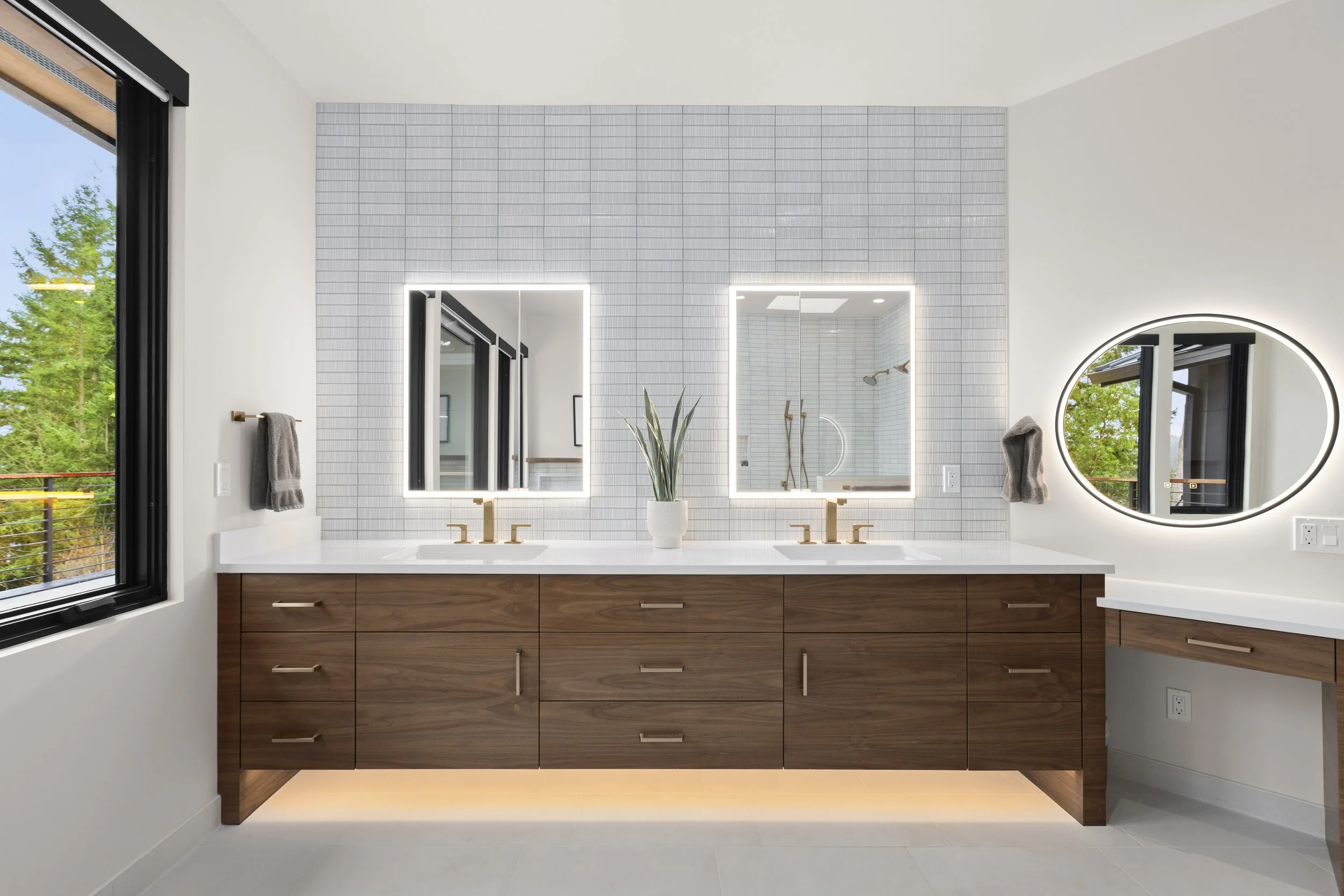 Secondary bathroom vanity detail with walnut cabinetry and tile backsplash
