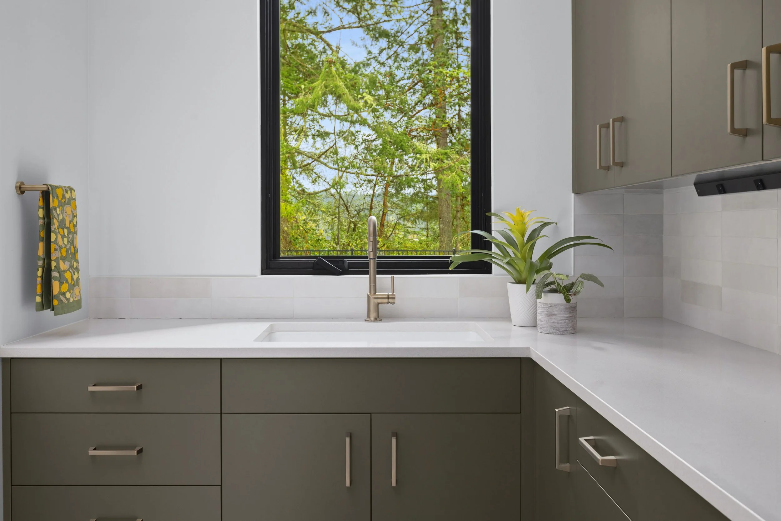 Laundry room with custom cabinetry, utility sink, and front-load washer and dryer