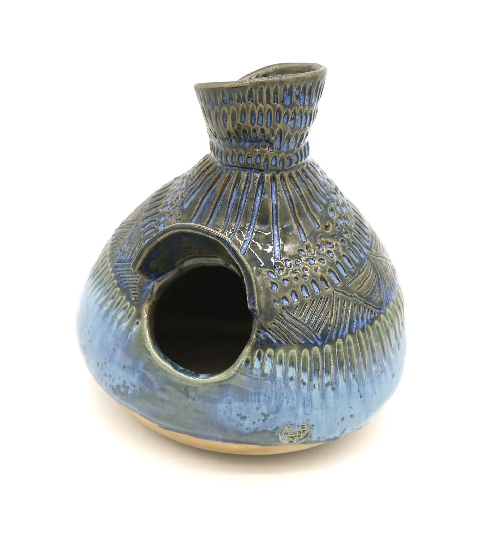 Ceramic vase with a rounded body, narrow neck, and a small circular opening, featuring textured blue glaze with decorative patterns.