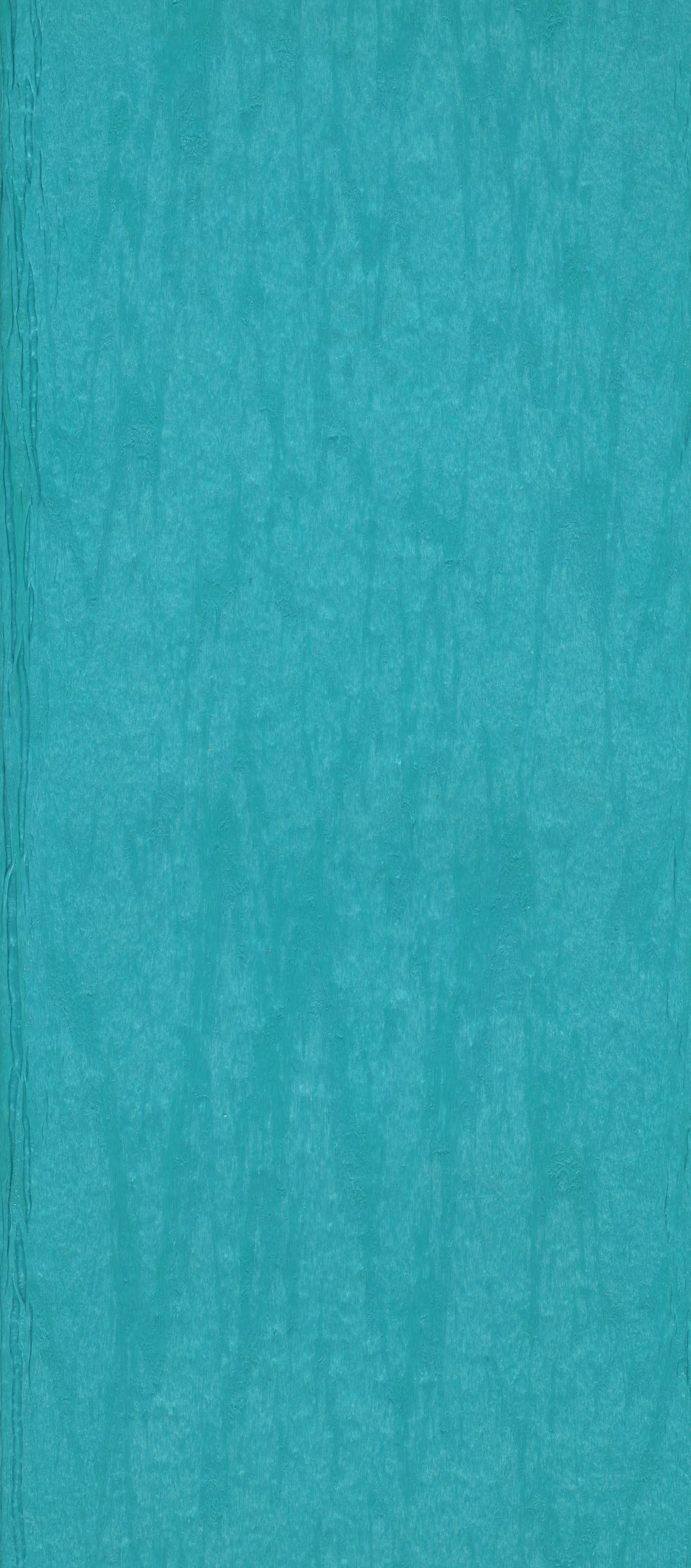 Close-up of a textured turquoise surface, possibly paper or fabric.