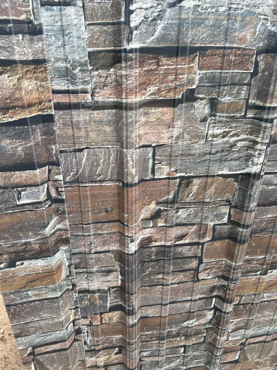 Close-up of a stone or brick wall with a textured surface.