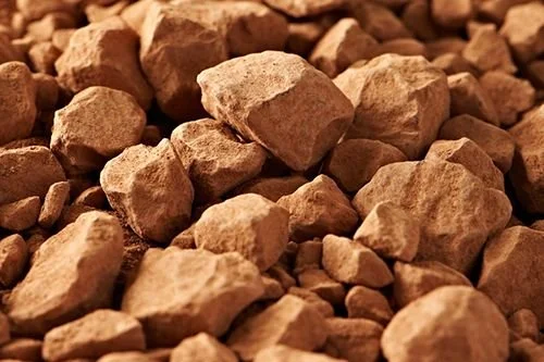 Pressed cocoa cake pieces close-up — by-product of butter extraction used for cocoa powder.