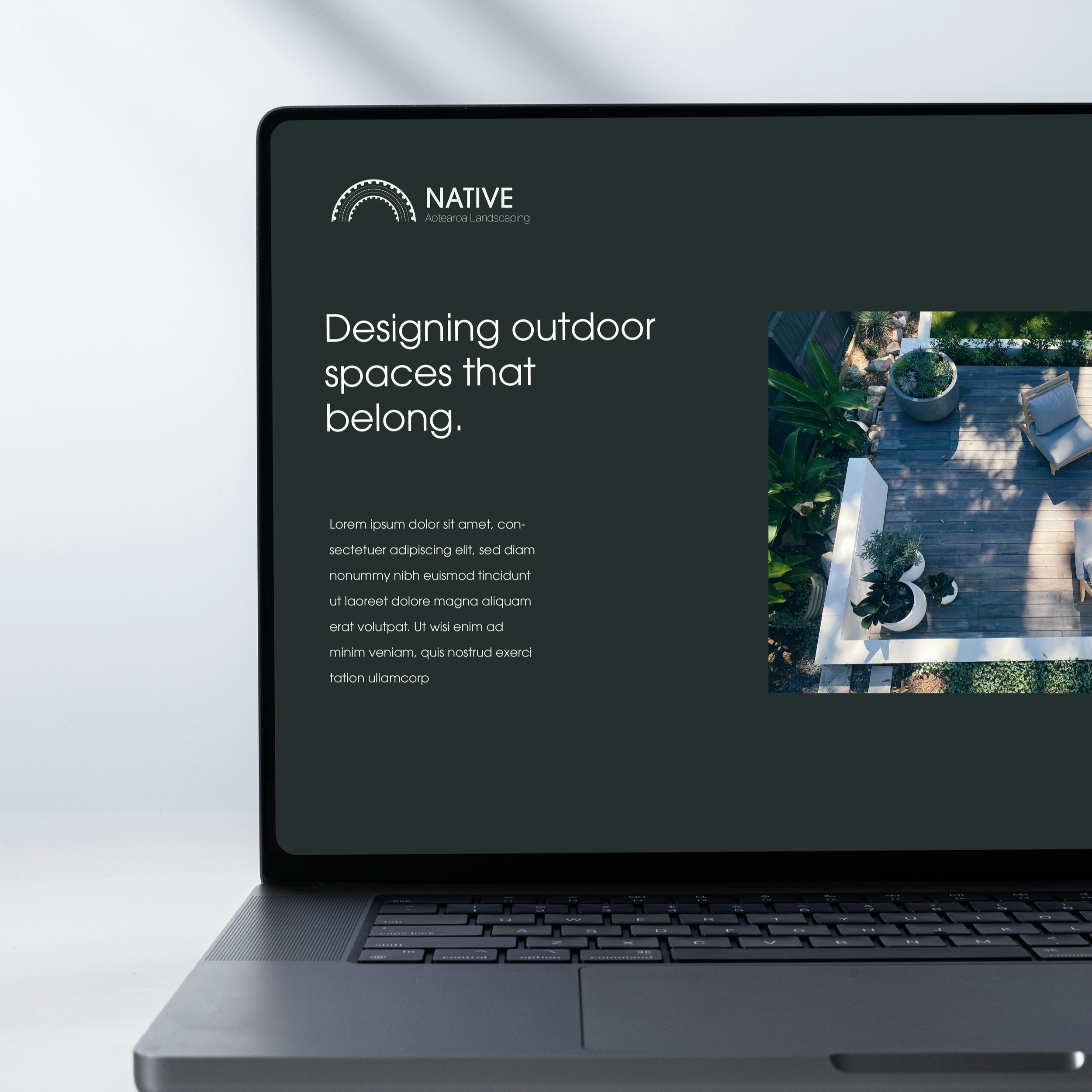 Laptop screen displaying a website for Native, a landscaping company, with the headline "Designing outdoor spaces that belong" and a photo of a landscaped outdoor patio with plants and seating.