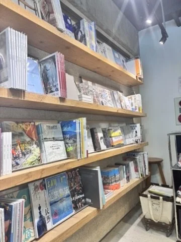 Wooden bookshelves filled with books and magazines in a retail store.