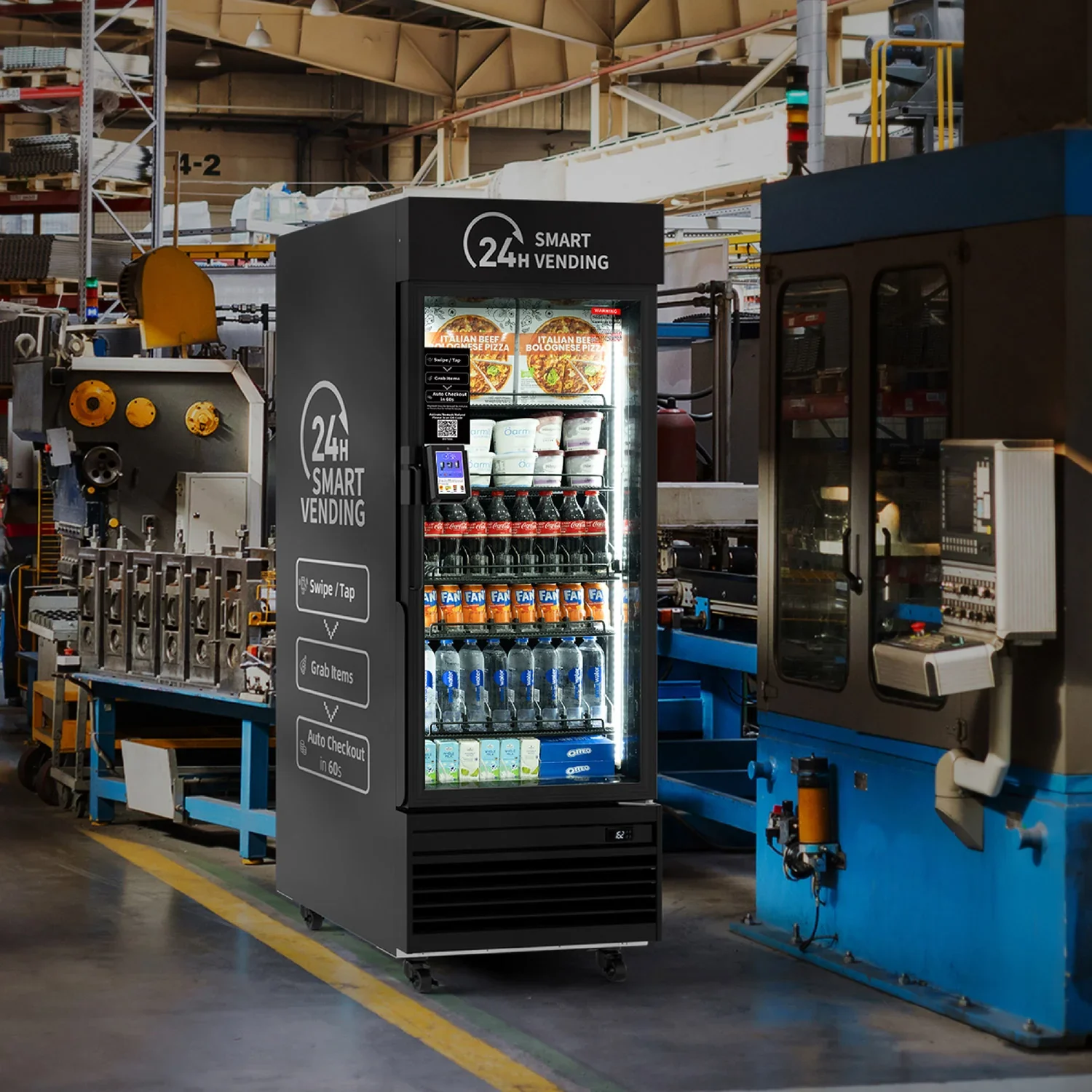 A 24-hour smart vending machine in a factory, stocked with beverages and snacks, displaying digital screen and instructions on the side.