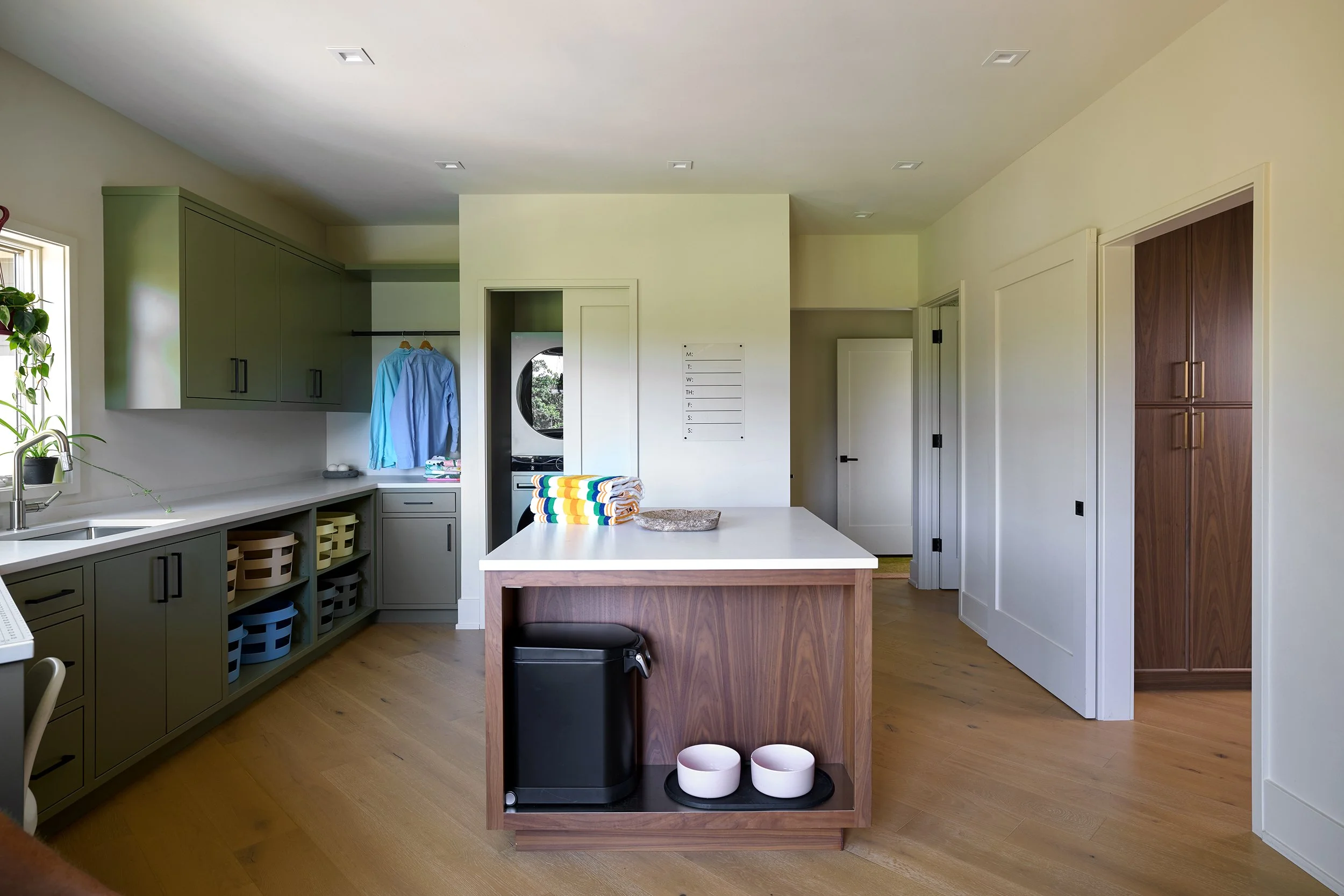 Clean and organized laundry room with ample countertop space and undercounter dog food station