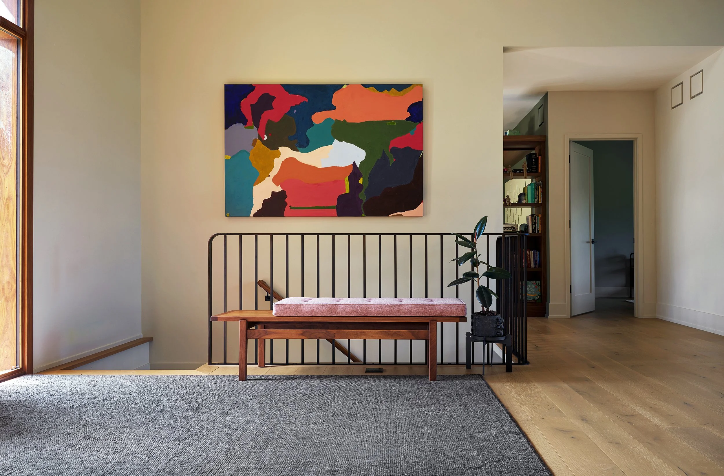 Entryway with bench, custom steel staircase railing and colorful art