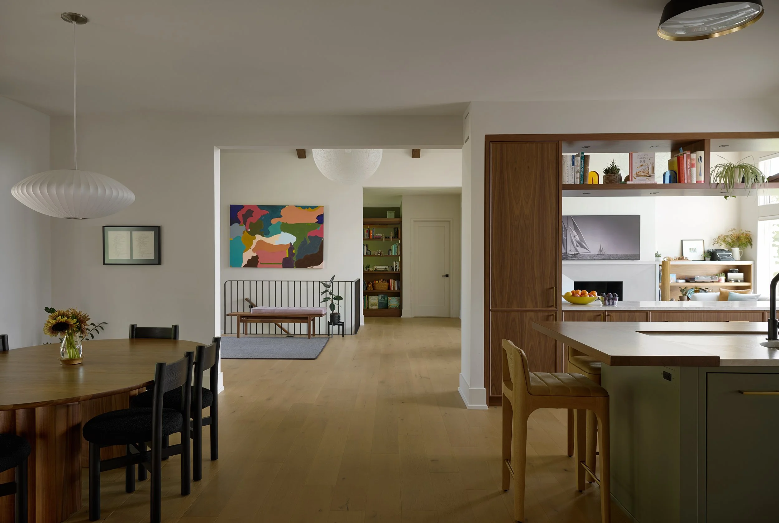 Modern open kitchen and intimate dining space overlook the home's entryway